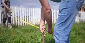 People measuring land in sections and placing stakes to obtain square meters